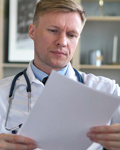 мужчина врач смотрит записи на бумаге